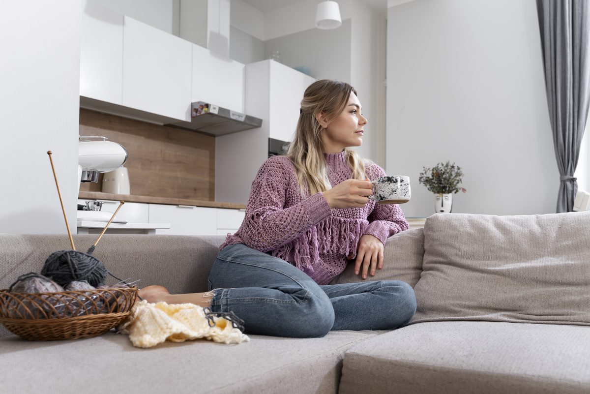 Kvinna som vilar i soffan i sitt hem